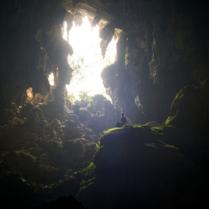 Pvk Photo | Photographe Professionnel | Femme assise en contre-jour dans la grotte de tham Poukham à Vang Vieng au Laos