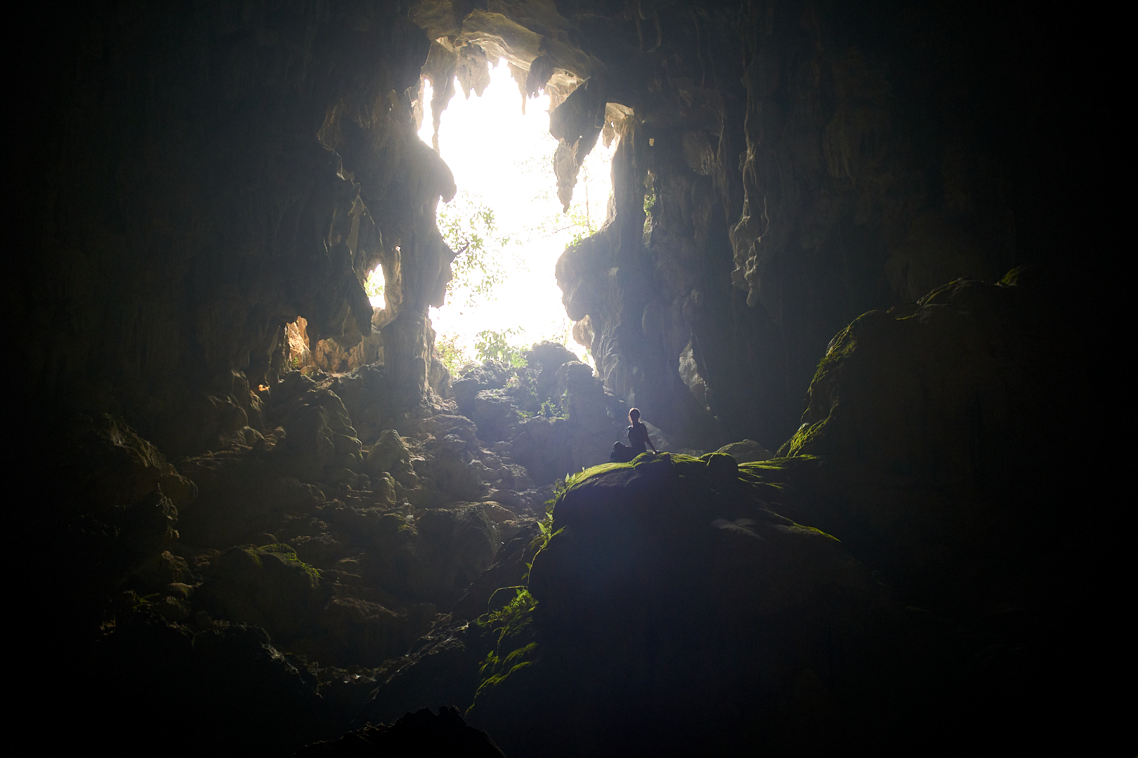 Pvk Photo | Photographe Professionnel | Femme assise en contre-jour dans la grotte de tham Poukham à Vang Vieng au Laos