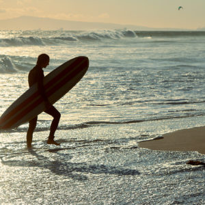 Pvk Photo | Surfeur sortant de l'eau en contre jour Huntington Beach, Californie